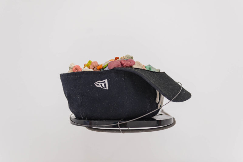 Carlos Sandoval de León, Untitled (Doing Two Things At Once), 2018. Fitted hat, chewing gum, obsidian disc. Courtesy the artist and CENTRAL FINE, Miami Beach.